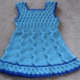 Vestido de malha para uma menina com agulhas de tricô silhueta A