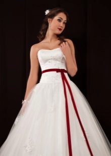 Gaun perkahwinan yang berbulu dengan pinggang yang rendah dan tali pinggang merah
