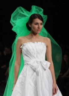 Vestido de novia blanco con velo verde.
