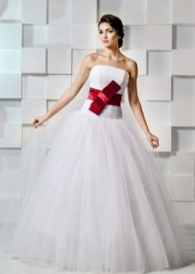 Magnífico vestido de novia con lazo rojo.