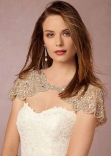 Estuche de vestido de novia blanco en combinación con una capa de encaje beige en los hombros