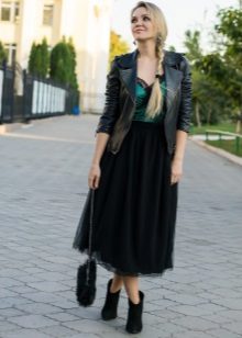 Lang lagdelt sort nederdel i kombination med en jakke