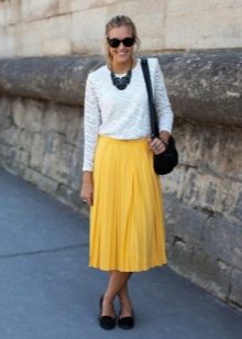 Gele rok onder de knie in combinatie met een witte blouse