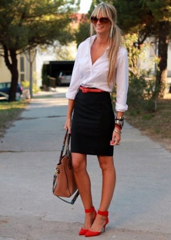 Falda lápiz negra en combinación con una camisa blanca y zapatos rojos.
