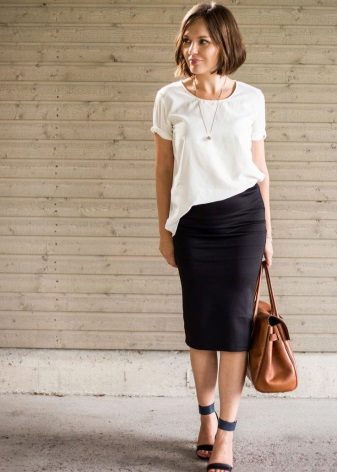 Falda lápiz negra combinada con una blusa blanca.