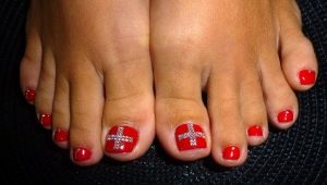 Features create a red pedicure with rhinestones