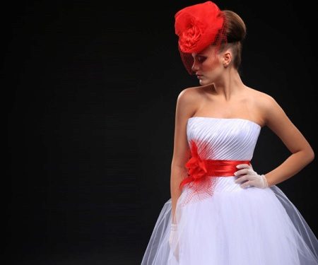 Brudekjole med et rødt bælte og en hat