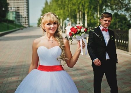 فستان زفاف مع حزام أحمر وباقة حمراء