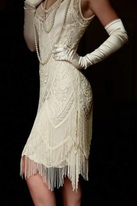 Baltos spalvos suknelė su asimetrišku sijono dugnu, Gatsby stiliaus, kartu su pirštinėmis ir perlais
